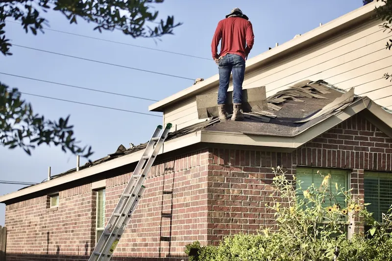 Professional roofer working on a residential roof in East Hartford Gardens